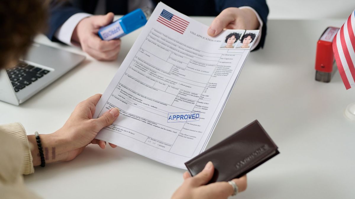 Immigration documents and American flag representing USCIS adjustment of status policy changes in 2026